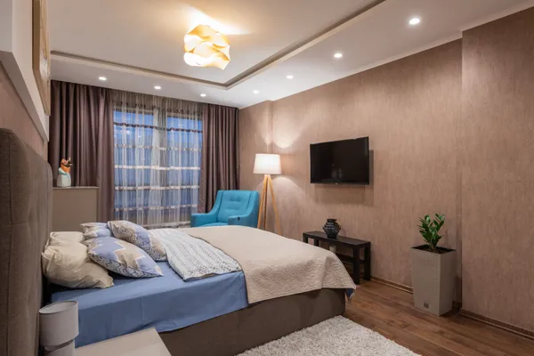 Inviting bedroom featuring a comfortable bed, cozy furnishings, and elegant lighting.