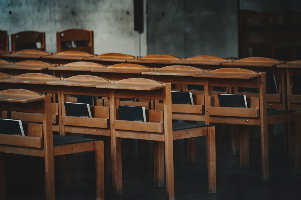 Rows of vintage wooden chairs in a classroom setting in Vienna, Austria.