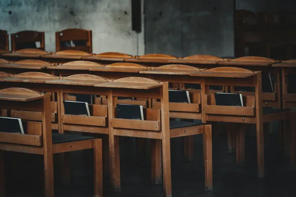 Rows of vintage wooden chairs in a classroom setting in Vienna, Austria.